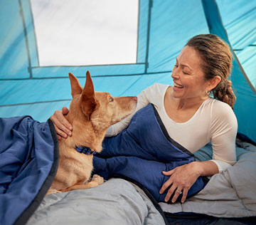 woman-camping-with-dog-sleeping-bag