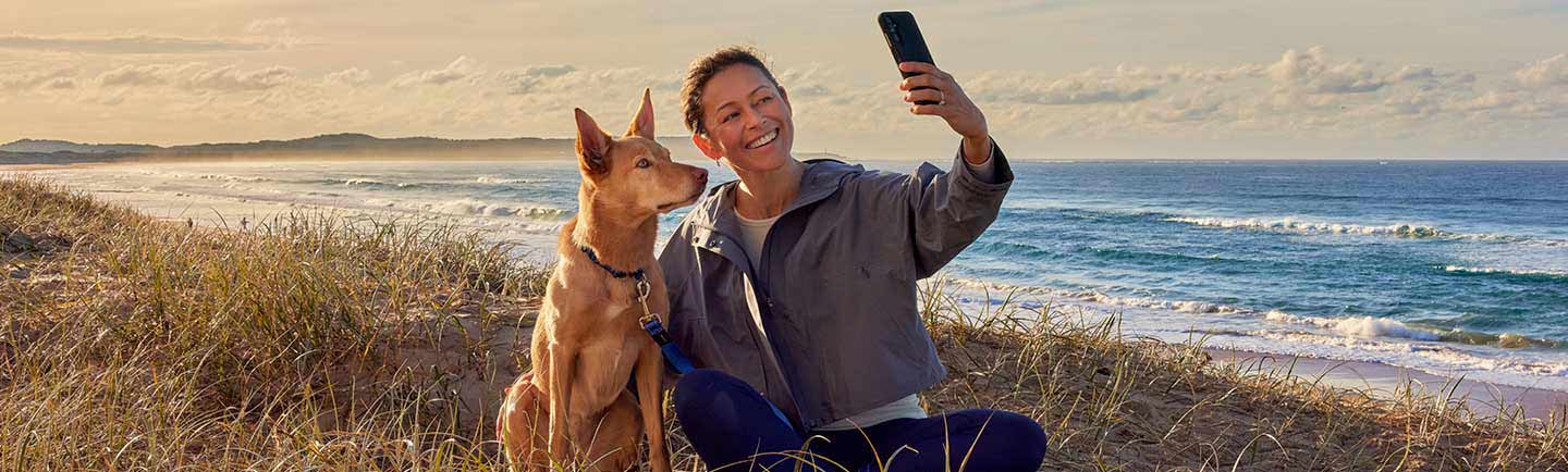 a-woman-taking-selfie-with-dog-on-a-beach-in-New-Zealand