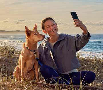 a-woman-taking-selfie-with-dog-on-a-beach-in-New-Zealand